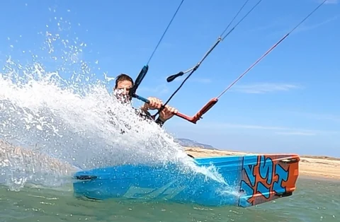 Suda board ile ilerleyen kitesurf sporcusu