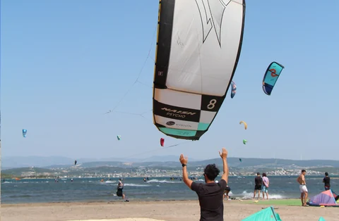 Uçurtmasını sahilden kaldıran kitesurf katılımcısı